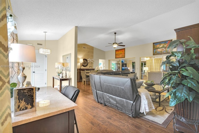 interior space featuring decorative light fixtures, ceiling fan, a textured ceiling, lofted ceiling, and dark wood-type flooring