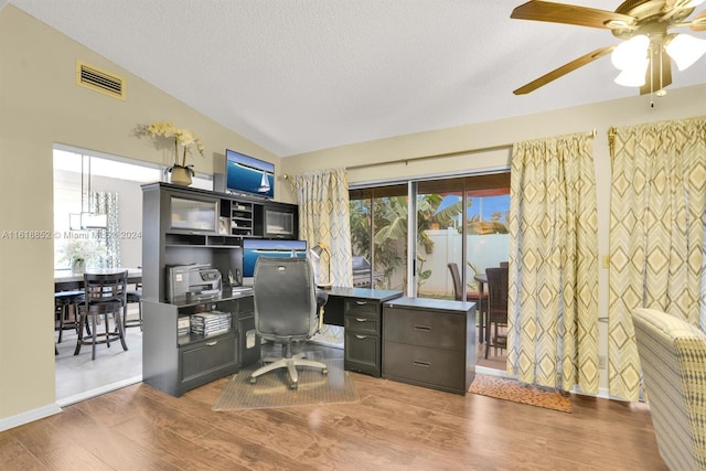 office space featuring lofted ceiling, visible vents, a textured ceiling, and wood finished floors