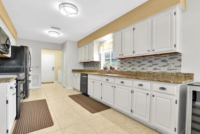 kitchen with white cabinetry, light tile patterned floors, decorative backsplash, and stainless steel appliances