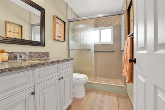 bathroom featuring vanity, toilet, tile patterned floors, and a shower with door