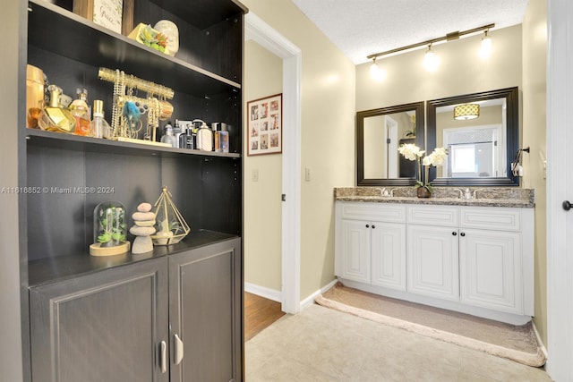 bathroom with vanity, tile patterned floors, a textured ceiling, and track lighting