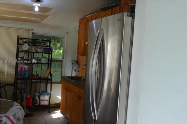 kitchen featuring stainless steel fridge and light tile patterned flooring