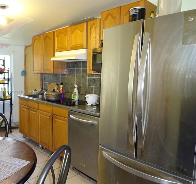 kitchen featuring light tile patterned flooring, backsplash, appliances with stainless steel finishes, and sink