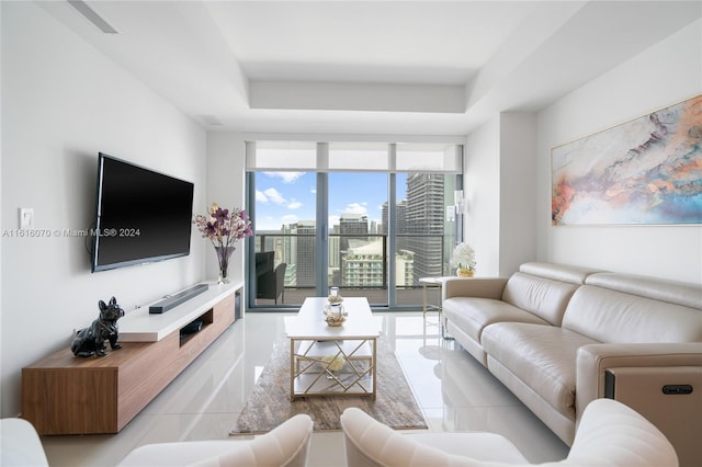 tiled living room featuring a raised ceiling