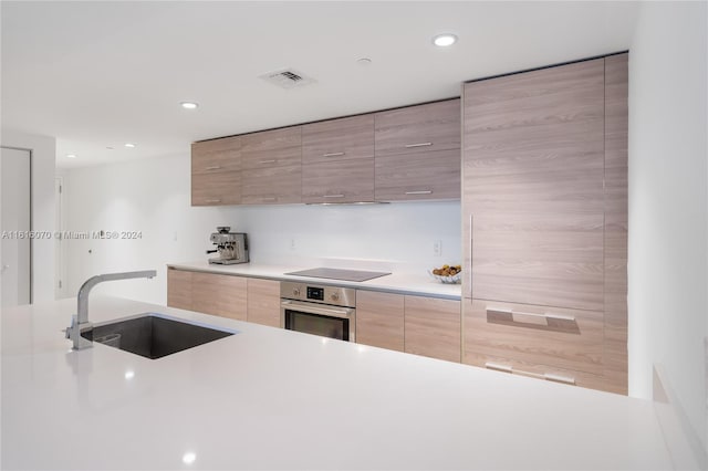 kitchen featuring sink, stainless steel oven, extractor fan, and black electric stovetop