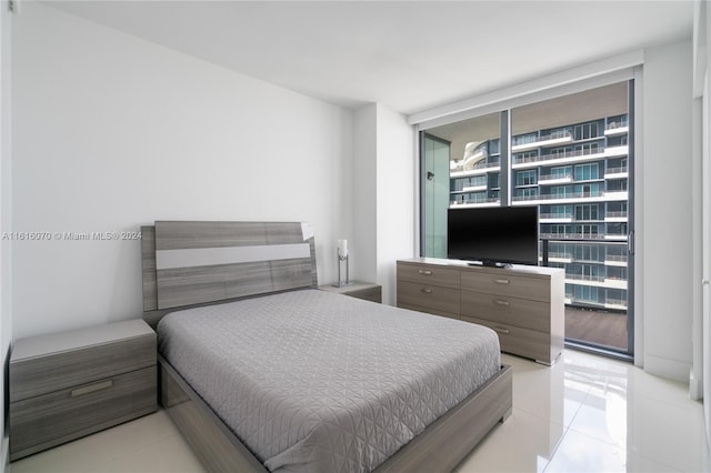 tiled bedroom featuring a wall of windows