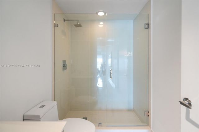 bathroom featuring walk in shower and toilet