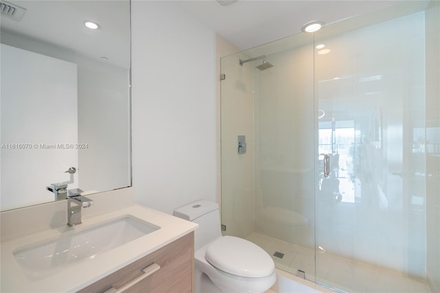 bathroom with walk in shower, toilet, and vanity