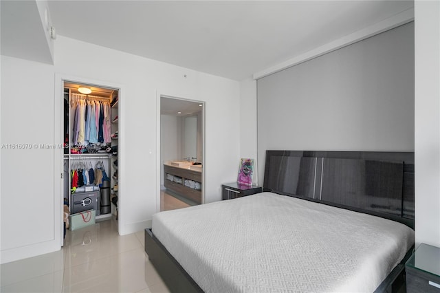 bedroom featuring a walk in closet, a closet, light tile patterned floors, and ensuite bathroom