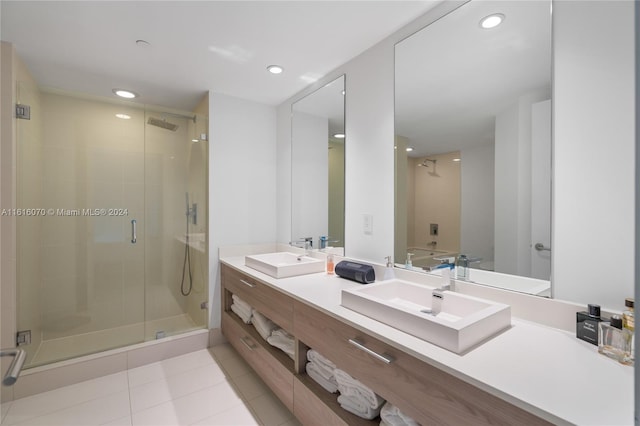 bathroom with tile patterned flooring, dual vanity, and a shower with shower door