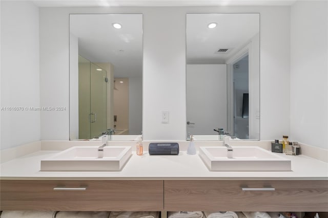 bathroom with walk in shower and dual bowl vanity