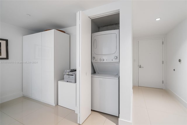 washroom featuring light tile patterned flooring and stacked washer / drying machine