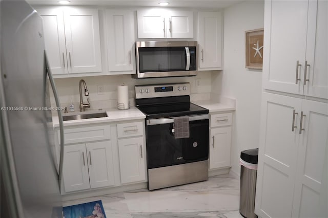 kitchen with sink, white cabinetry, light tile patterned flooring, and stainless steel appliances