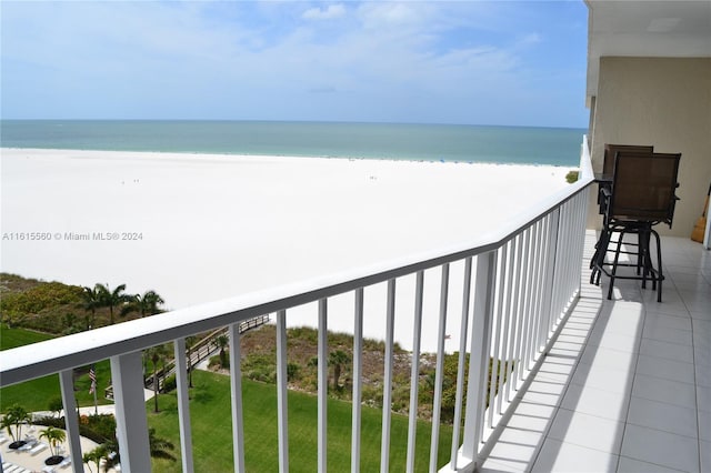 balcony with a water view and a view of the beach