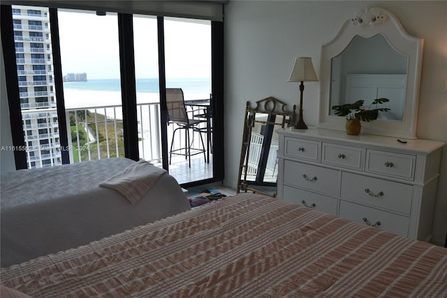 bedroom with access to outside and a water view