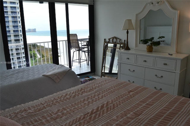 bedroom featuring a water view and access to exterior