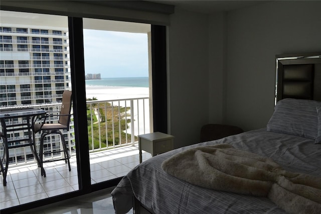 tiled bedroom with a view of the beach and a water view