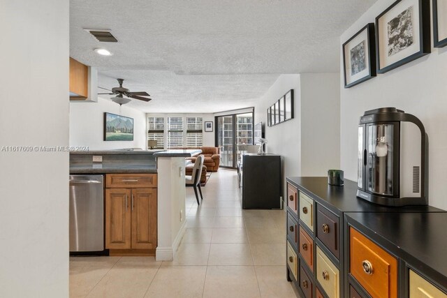 1915 Brickell Ave Unit C506, Miami, FL 33129 - kitchen with a textured ceiling, dark countertops, stainless steel dishwasher, brown cabinets, and open floor plan