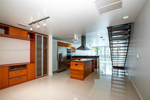 kitchen with ventilation hood, a center island, light tile patterned floors, and stainless steel appliances