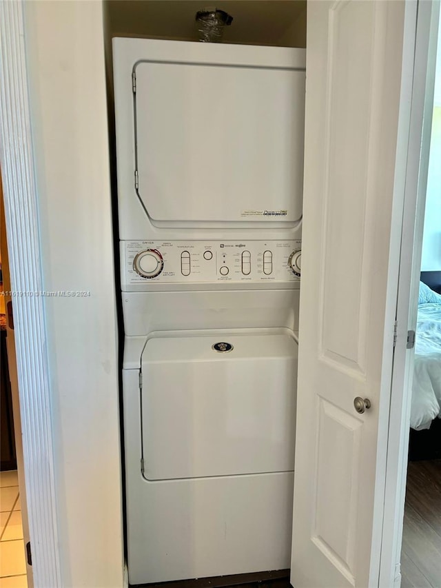 laundry area featuring light tile patterned floors and stacked washer and dryer