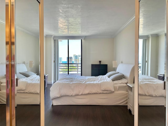 bedroom with multiple windows, a wall of windows, dark hardwood / wood-style flooring, and crown molding