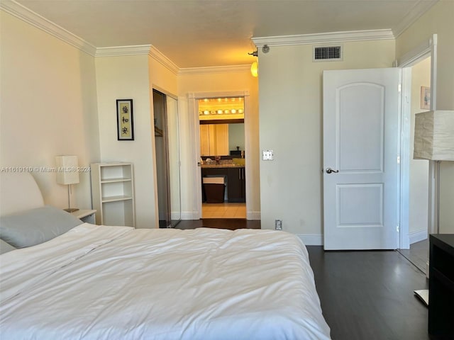 bedroom featuring dark hardwood / wood-style floors, a closet, and ornamental molding