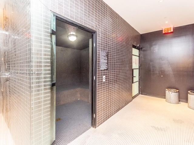 hall with tile walls and tile patterned floors