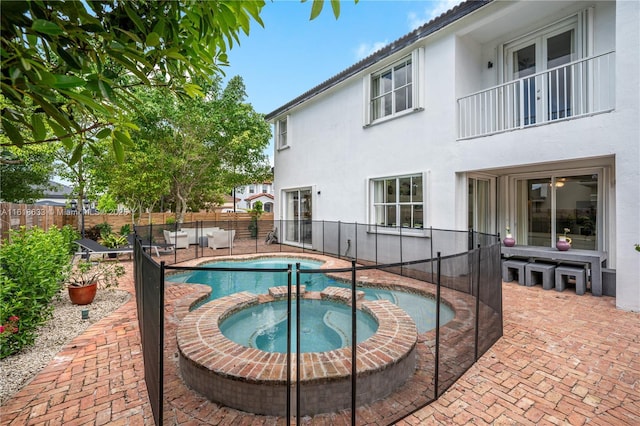 view of pool featuring a pool with connected hot tub, a fenced backyard, and a patio