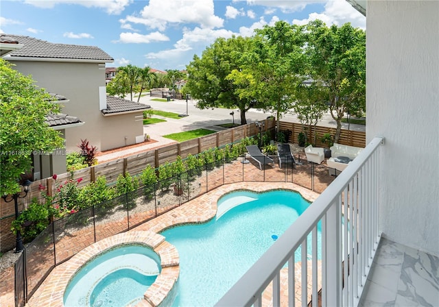 view of pool featuring a patio area, a fenced backyard, and a pool with connected hot tub