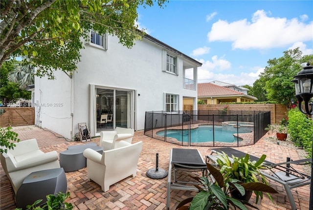 view of swimming pool featuring a patio area, a fenced backyard, and a pool with connected hot tub