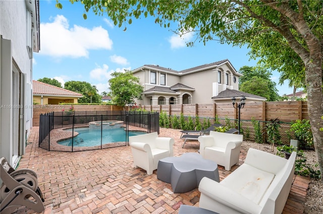 view of swimming pool featuring a pool with connected hot tub, a fenced backyard, a patio, and an outdoor living space