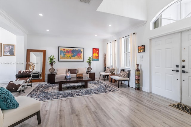 living area featuring crown molding, baseboards, wood finished floors, and recessed lighting