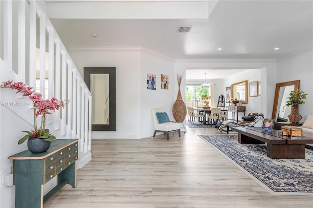 interior space featuring light wood-style floors, visible vents, ornamental molding, and baseboards