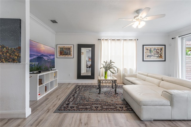 living area with ceiling fan, wood finished floors, visible vents, baseboards, and crown molding