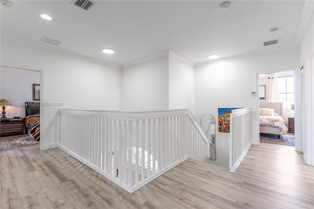 entryway featuring ornamental molding, a wealth of natural light, and light hardwood / wood-style floors