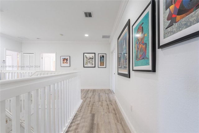 hallway with ornamental molding and light hardwood / wood-style flooring