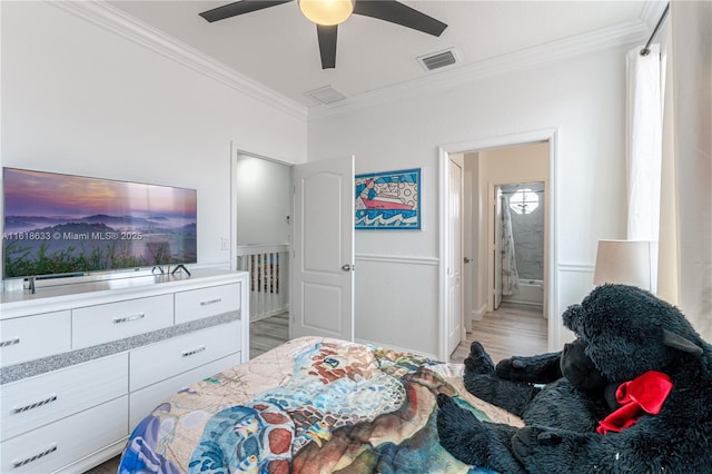 bedroom with ensuite bath, light wood-style flooring, visible vents, and ornamental molding