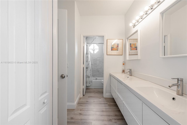 full bath featuring double vanity, wood finished floors, shower / washtub combination, and a sink