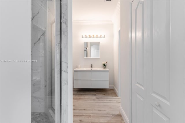 bathroom with wood-type flooring, vanity, crown molding, and an enclosed shower