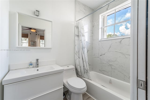 full bathroom featuring hardwood / wood-style floors, shower / bath combo with shower curtain, ceiling fan, vanity, and toilet