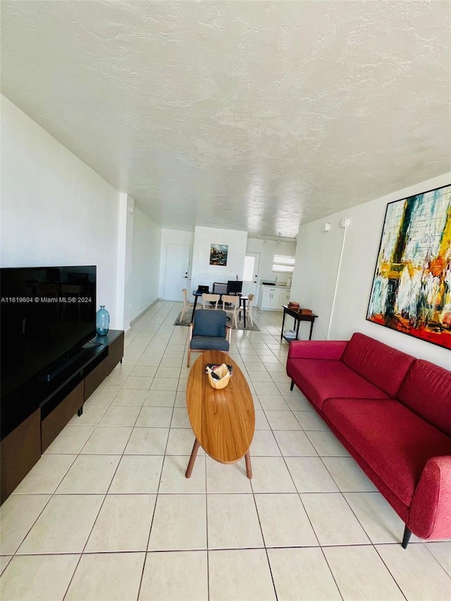 tiled living room featuring a textured ceiling