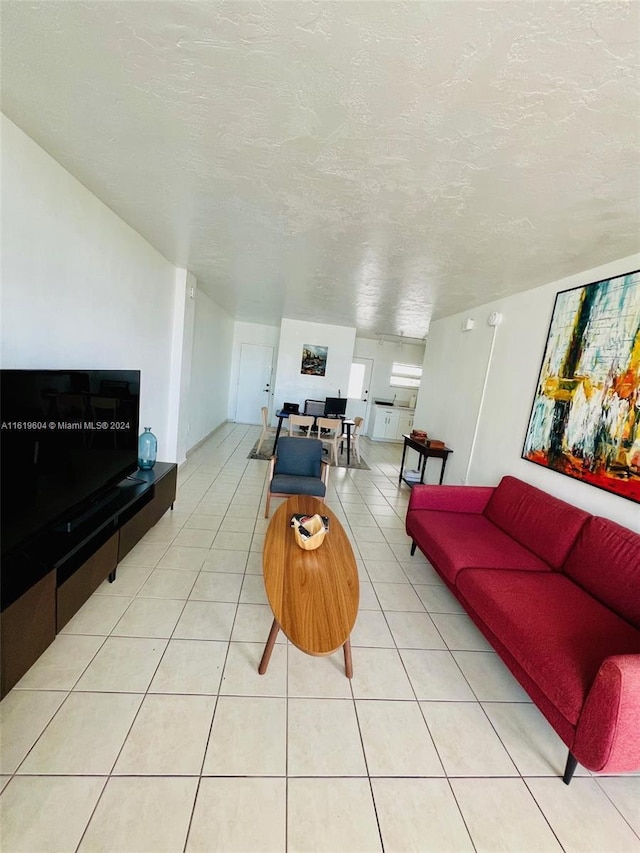 tiled living room featuring a textured ceiling