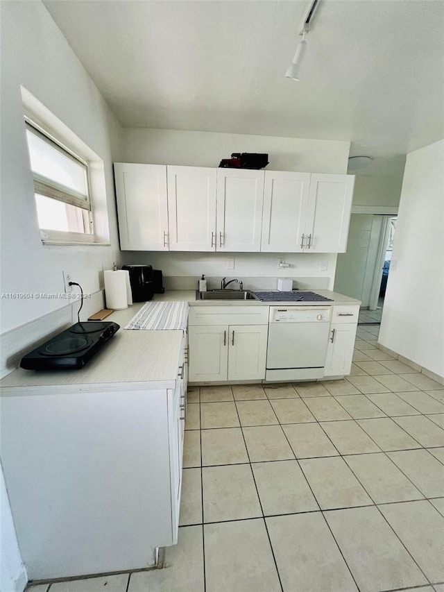 kitchen featuring rail lighting, sink, white cabinetry, light tile patterned floors, and dishwasher