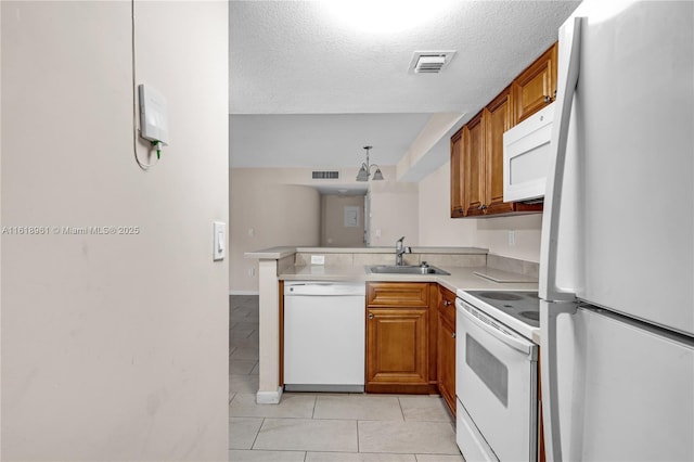 kitchen with white appliances, a textured ceiling, light tile patterned floors, sink, and kitchen peninsula