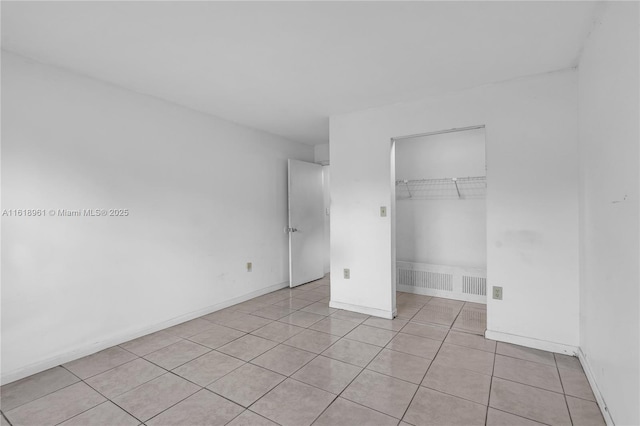 unfurnished bedroom featuring a closet, a spacious closet, and light tile patterned floors