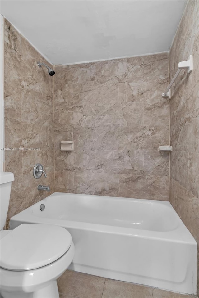 bathroom featuring tile patterned floors, toilet, and tiled shower / bath