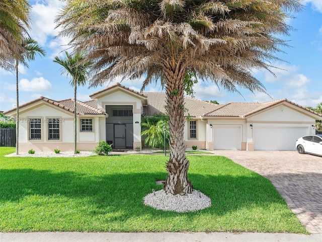 mediterranean / spanish-style house featuring a front yard and a garage