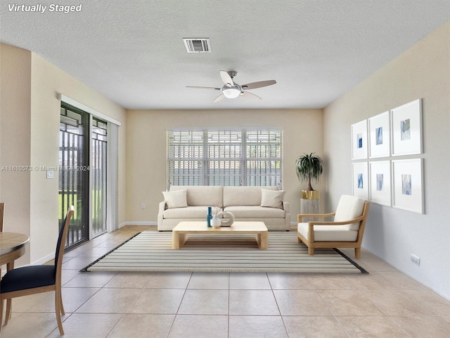 tiled living room featuring a textured ceiling and ceiling fan