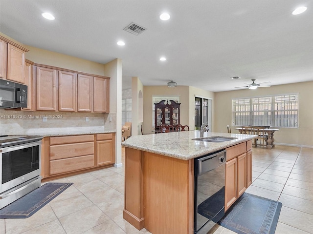 kitchen featuring decorative backsplash, a kitchen island with sink, sink, black appliances, and ceiling fan