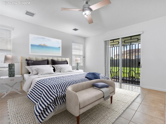 tiled bedroom featuring ceiling fan, access to outside, and multiple windows